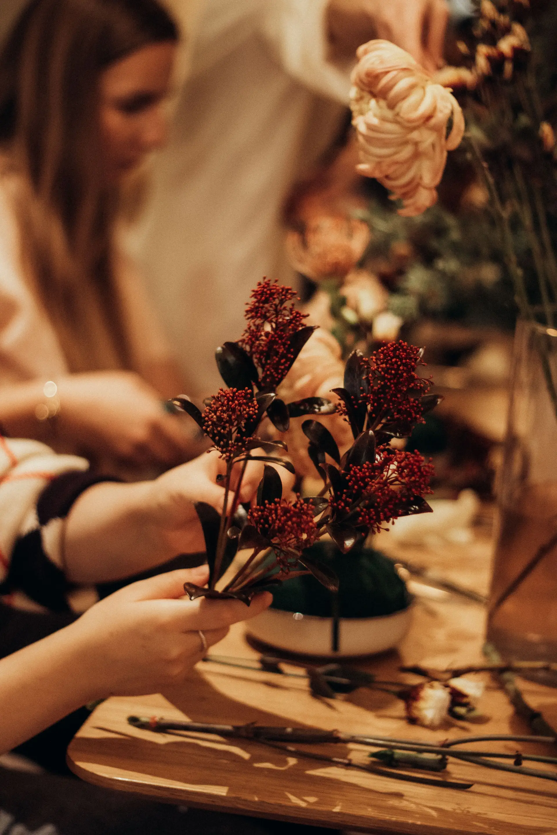 Adults arranging colorful seasonal flowers during workshop