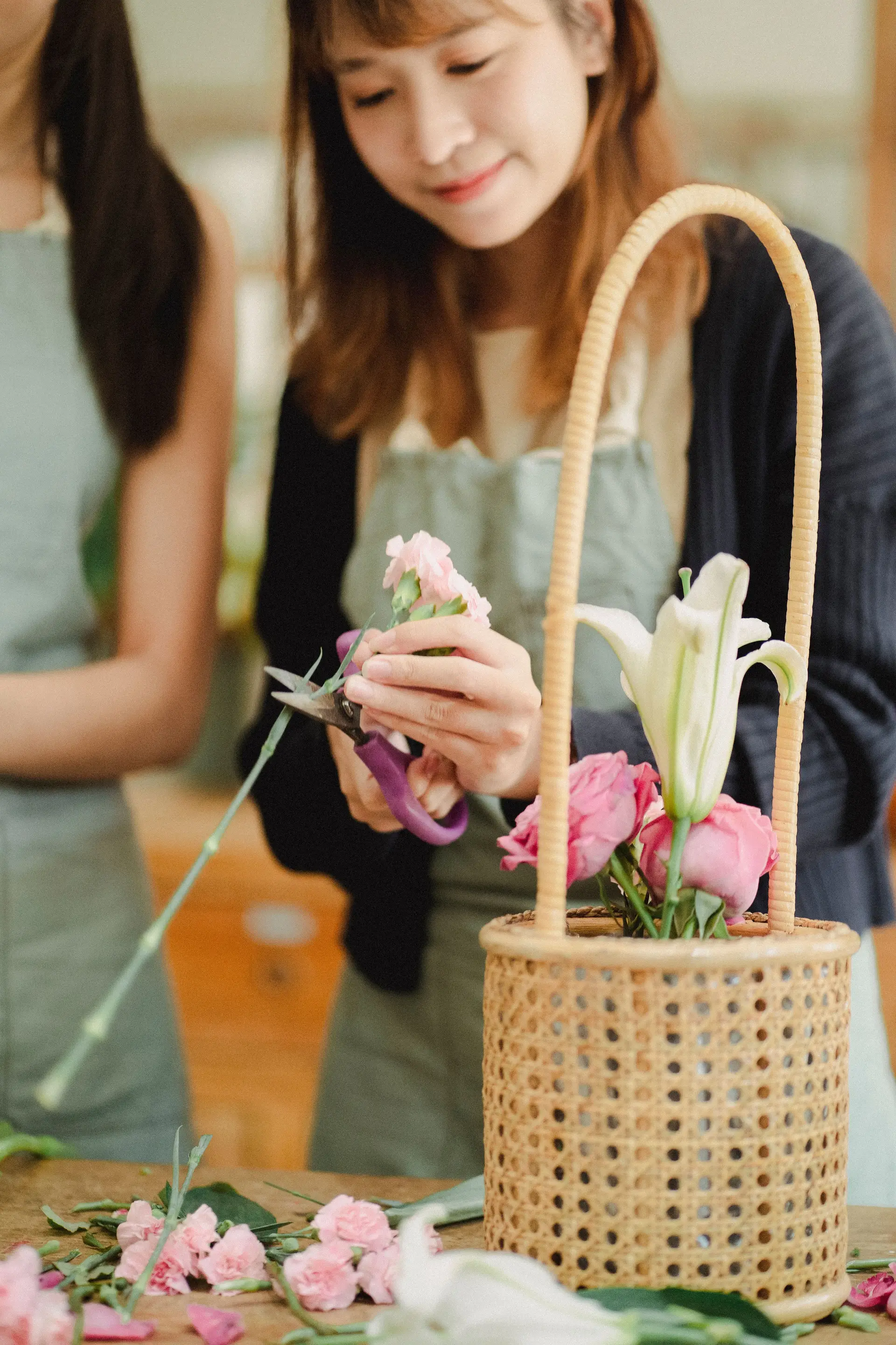 Florists collaborating on a large floral wicker basket